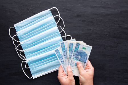 Face mask and polish zloty (zÅ‚oty) banknotes on black background. Poland expensive charges for...
