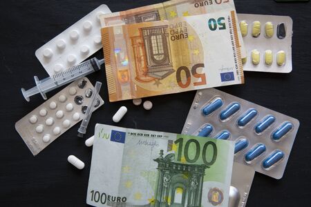 Medical and health costs during coronavirus crisis. Epidemic covid-19 concept in European Union. Euro (EUR) banknotes and pills.の写真素材