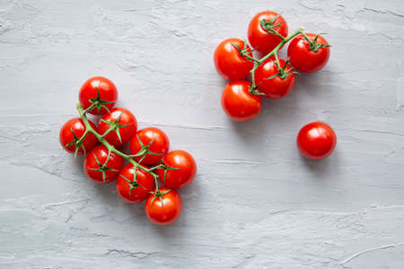 Fresh red cherry tomatoes on grey concrete background, top view. の写真素材