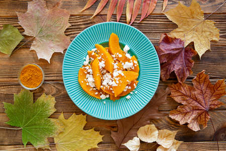 Bright autumn colorful salad and dried leaves background, top view.の写真素材
