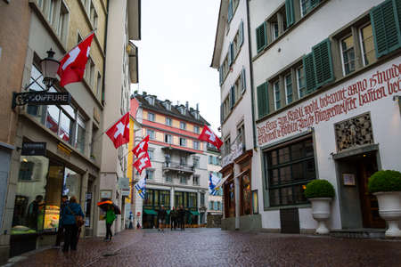 Zurich, Switzerland -16 April 2017. Beautiful old street with shops and a lot of flags.のeditorial素材