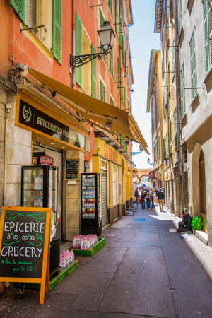 Nice, France - April 18 2017. Colorful narrow street in Nice, French riviera. Souvenir shops and turists.のeditorial素材