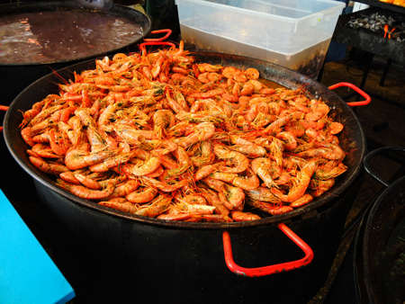 Big tiger shrimps on large pan, fresh cooked seafood on market, healthy food.の写真素材