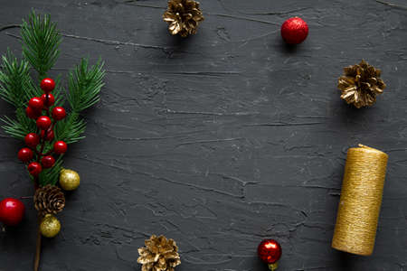Christmas background, golden cones, fir branch and festive decorations on black background, space...