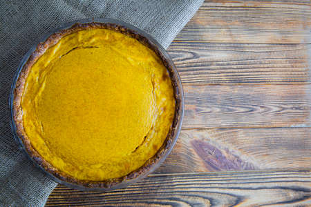 Pumpkin pie dessert on rustic wooden table, top view. Space for text, copy space.