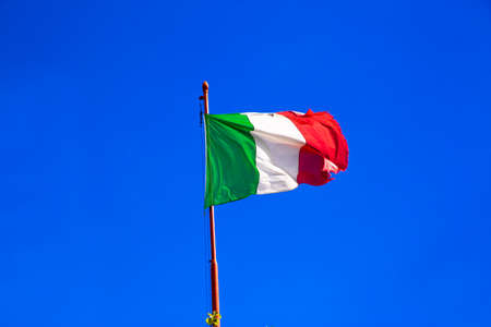 Italian flag waves on bright blue sky in sunny day. Italy.の写真素材