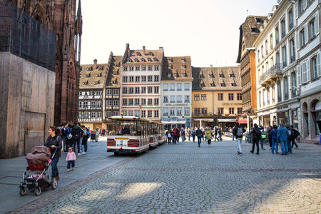 2 of May 2022, Strasbourg, France. Place de la cathedrale de Strasbourg, tourist train and a lot of people near cathedral.のeditorial素材