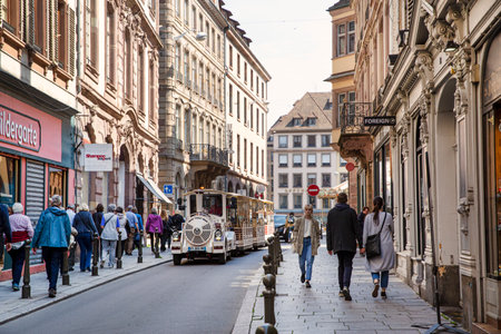 2 of May 2022, Strasbourg, France. Cozy beautiful street in Strasbourg, with old medieval architecture. Tourist train, shops and walking people.のeditorial素材