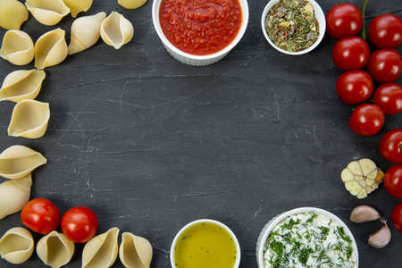 Food ingredients frame: italian pasta conchiglie, tomatoes, ricotta, sauce, copy space, space for...
