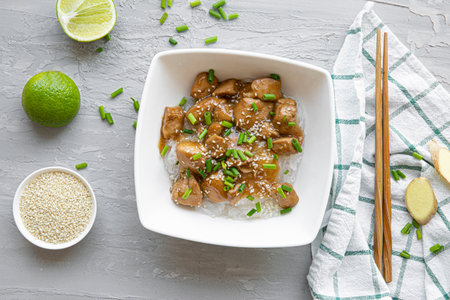 A plate of thai glass noodles with chicken, lime, sesame and cilantro on gray concrete background, top view.の写真素材