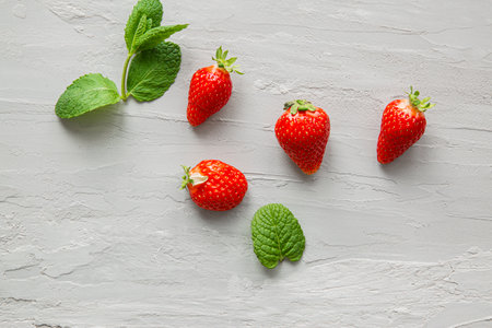 Strawberry and mint leaves on marble background, top view.の写真素材