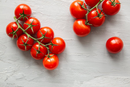 Fresh cherry tomatoes on gray background, top view.の写真素材