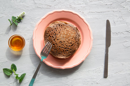 Tasty homemade chocolate pancakes with fresh peaches and honey, top view.の写真素材