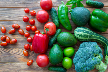 Assortment of green and red vegetables on wooden background, top view.の写真素材