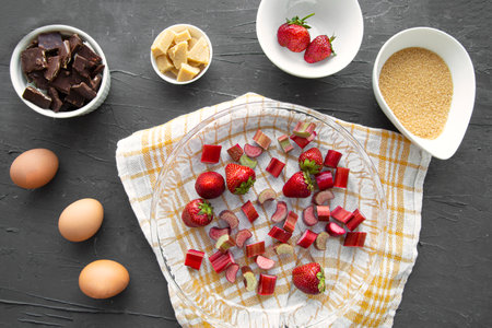 Summer fruit cake preparation. Baking tart or pie with strawberry or rhubarb, top view.の写真素材