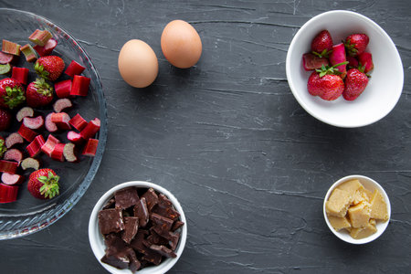 Fruit cake preparation. Baking pie or tart with strawberry and rhubarb, bakery ingredients, top view.の写真素材
