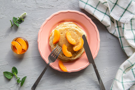 Tasty homemade pancakes with fresh peaches and honey, top view.の写真素材