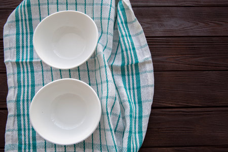 Empty plates on kitchen towel on wooden table, top view. Diet or cooking concept.の写真素材
