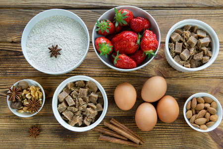 Preparation of summer pastry with strawberry and spices on rustic wooden background, top view.の写真素材