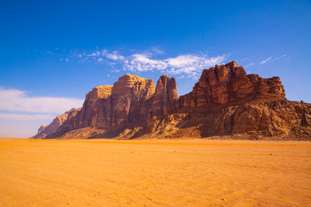Wadi Rum desert in Jordan. Yellow or orange sand dunes and rocky mountains, bright blue sky.の写真素材