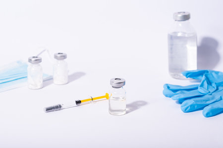 vaccine, doctor, researcher holds hands syringe in blue glove holding flu, measles, rubella or hpv vaccine and syringe with needle vaccination for baby, child, woman or man shot.の写真素材