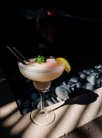 Tropical cocktail on a background of tropical plant leaves and sun shades. on a background of tropical plant. Color background.の写真素材