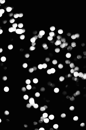 abstract black and white bokeh defocused lights on black backgroundの写真素材
