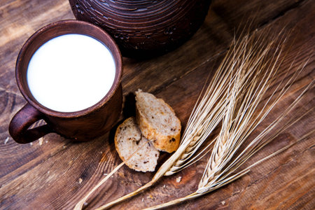 Toast with milk and wheat ears on a wooden backgroundの写真素材