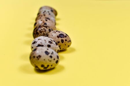 A row of Easter eggs on a yellow background. Easter concept. View from above. Place for an inscription. The basis for the postcard. Close-up.の写真素材