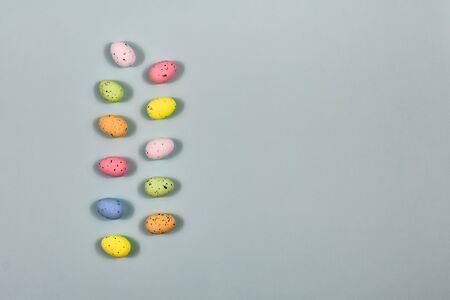 A row of Easter eggs on a yellow background. Easter concept. View from above. Place for an...