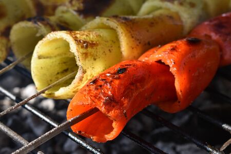 Sweet pepper on the grill. Roasted colorful bell pepper at on the grill. Red and yellow peppers. Grilled colorful yellow and red pepper grilled in the sun.の写真素材