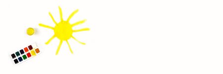 The sun is painted in yellow on a sheet of white paper. Children's creativity. Children's drawing. Banner.の写真素材