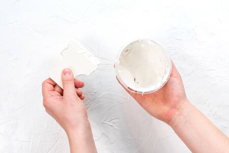 Female hands apply plaster on the wall. Putting plaster on the wall with a spatula.の写真素材