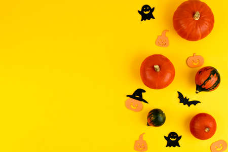 Autumn composition. Pumpkins, figurines, hat, bats, ghosts on a yellow background. Fall. Halloween concept. View from above. Place for your text.の写真素材