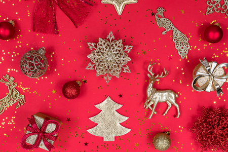 Gold and red Christmas decoration on a red background, top view, flat lay. New Year mood. The basis...