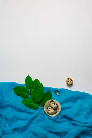 Easter clutch with quail eggs in a birds nest with linen cloth. Place for an inscription. View from above. Spring Easter decor.の写真素材