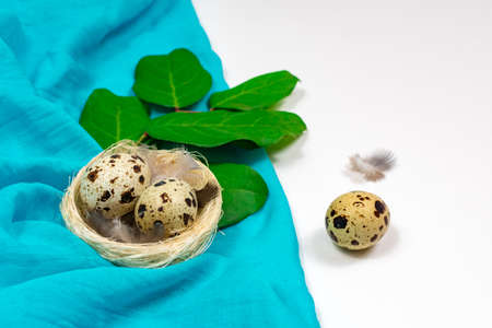 Easter clutch with quail eggs in a birds nest with linen cloth. Spring Easter decor.の写真素材