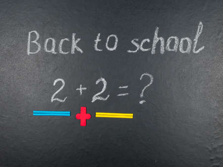 Multicolored colorful numbers, counting sticks, math signs on a chalkboard. Back to school. Concepts. School supplies on a chalkboard. View from above.の写真素材