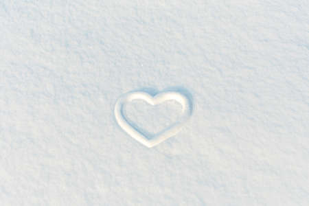Heart symbol drawn on fresh white snow. The basis for the postcard.