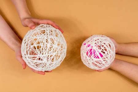 Snowman made of threads. Children and adults hands hold balls of threads. A set of items for making...