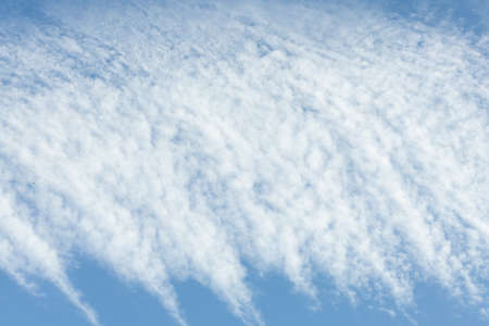 White cirrus clouds against the blue sky. Interesting background of blurry clouds.