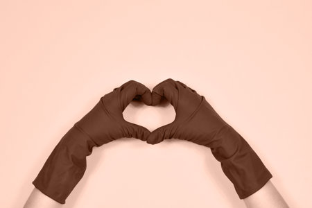 Working hands in rubber protective gloves show the heart.の写真素材