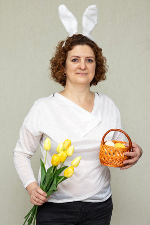 Woman enjoying Easter with yellow flowers and a basket of eggs