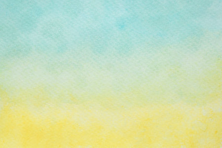 Soft abstract watercolor texture in serene yellow and light blue gradient huesの写真素材