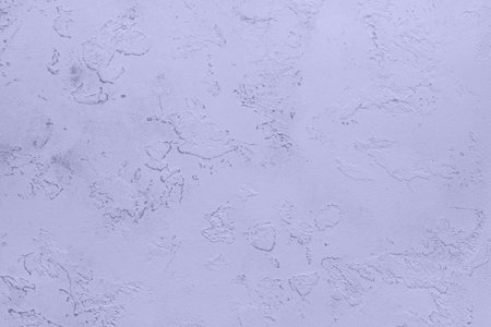 Textured light purple plaster wall with artistic abstract patterns and shadowsの写真素材