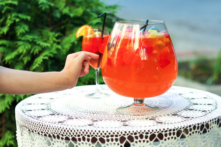 Refreshing lemonade with colorful gummy decorations on outdoor garden table