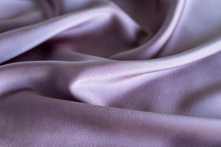 Luxurious purple fabric showcasing smooth and elegant folds in soft lightingの写真素材