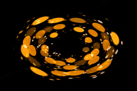 Abstract image of glowing golden circles with dark backgroundの写真素材