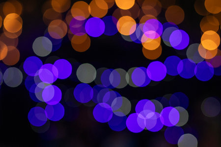 Soft bokeh lights in blue purple and orange create a dreamy abstract background for creative...