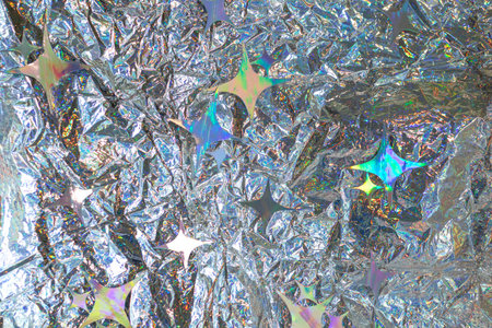 Shiny iridescent foil texture with stars and rainbow colors, abstract metallic background